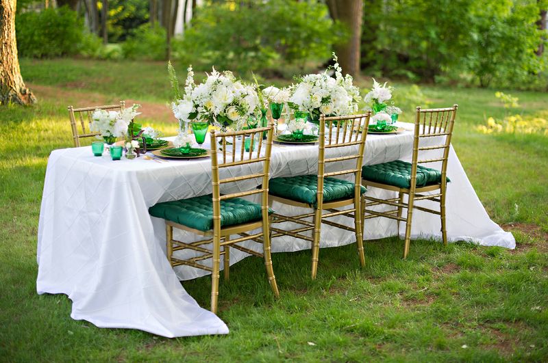 Outdoor reception table with green white and gold decor